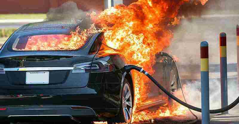 Electric car being charged catching fire at charger station.